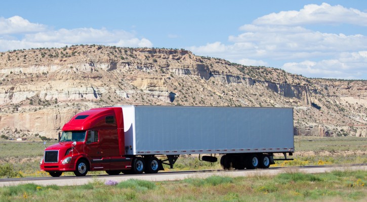 A semi-truck on the road in the desert