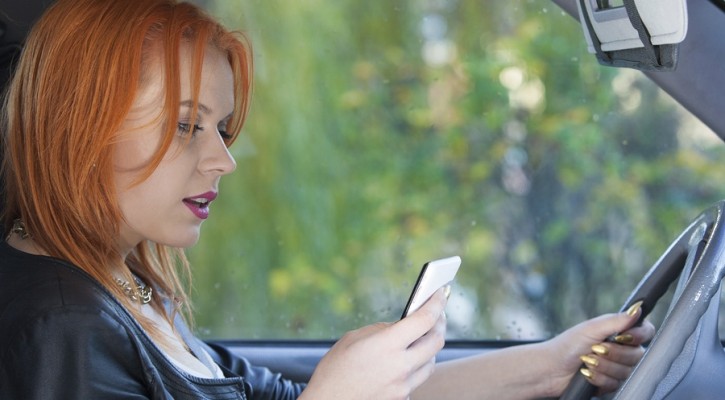 Woman Driver Sending Text Reading Message On Phone While Driving